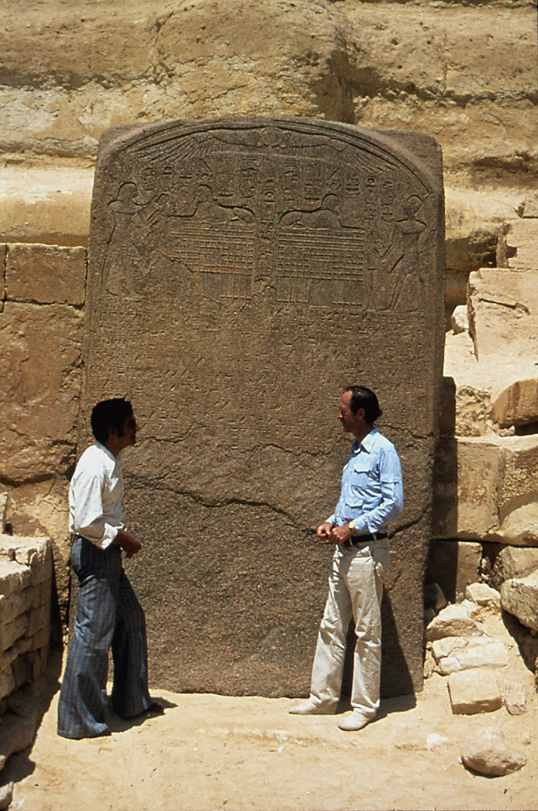 Color photo of 2 men standing in front of Thutmose's stela